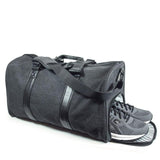 A charcoal cotton canvas duffel w/ black leather trim, inner lining & shoe compartment