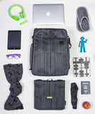 A suit grey Walter and Ray InTransit SLIM travel convertible backpack shown w/ carabiner, shoulder strap. head phones, slippers, Bendy Man light, scarf, eye glasses case, laptop, Insulated snack bag & passport.