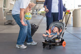 A family with a baby in a Travelmate Deluxe universal Infant/Toddler travel stroller with a seat adaptor with a strap for Infant Seats. It has smooth 6" rear polyurethane razor wheels and swivel wheels in the front. It also has a hands free foot brake feature.